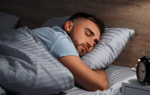 Young man sleeping in bed at night