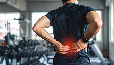 Man Experiencing Lower Back Pain After Workout at Gym.